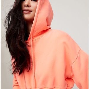 Bright pink cropped Aritzia TNA hoodie